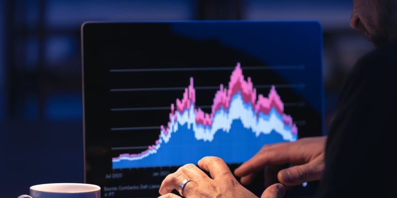 Broker looking at laptop analyzing stock market invest trading stocks graph.